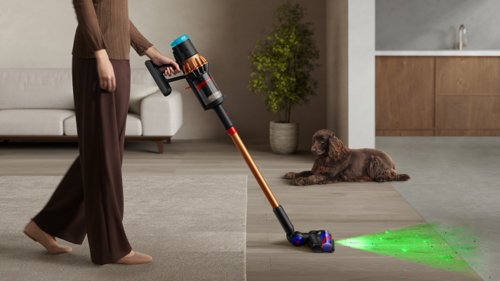 Woman using Dyson wet floor cleaner to clean spill on the floor